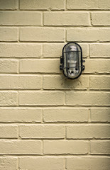 Industrial light on a seamless clean painted brick wall.