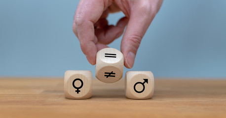 Symbol for gender equality. Hand turns a dice and changes a unequal sign to a equal sign between...