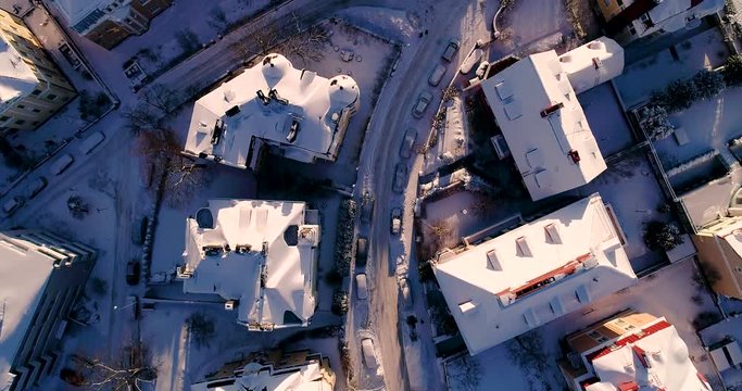 Urban view from flying above the houses and narrow streets on a winter day with snow
