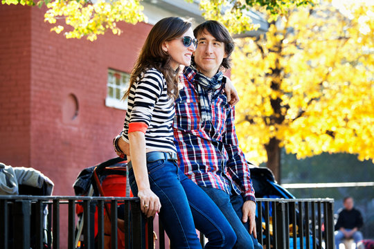 Couple sitting on railing in park 