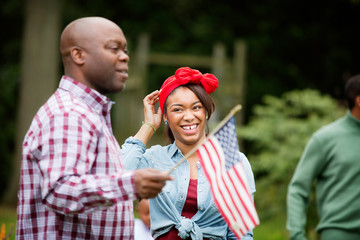 Teen girl laughing,  father holding American flag 