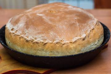 Kurnik, Russian pie with chicken, onion and potatoes. A traditional dish of dough lies on the table. © PAVEL GERASIMENKO