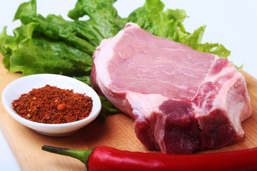 Raw pork chops with herbs and spices on cutting board. Ready for cooking.