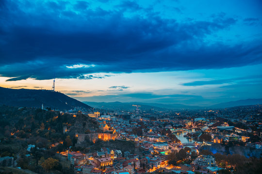 Tbilisi, Georgia. Top View Of Georgian Capital City Skyline Cityscape In Evening Night Illuminations. Georgian Capital Skyline Cityscape