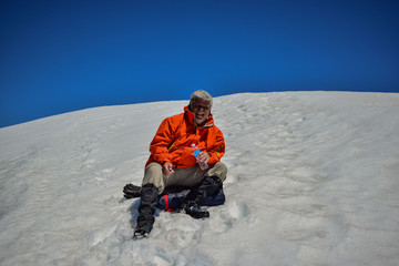 Fototapeta na wymiar hombre adulto descansando en una montaña nevada