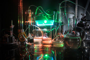 Pharmacy and chemistry theme. Test glass flask with solution in research laboratory. Science and medical background. Laboratory test tubes on dark toned background