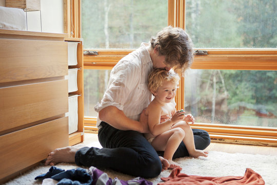 Father kissing son ( 2-3 ) while changing his clothes 
