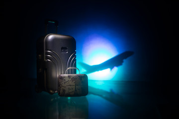 stack of traveling luggage in airport terminal and passenger plane flying over sky