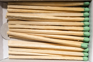 wooden matches with a green sulfur head, lie in a box, macro abstraction subject