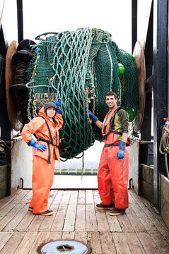 Fisherwoman and fisherman holding fishing nets 