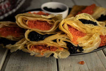 Pancakes close-up stuffed with caviar, mix