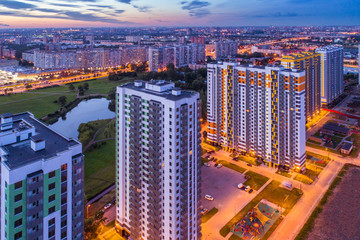 Evening panorama of urban residential quarter. Top view of the populated high-rise buildings and infrastructure. City Lights. Modern metropolis architecture. City building.