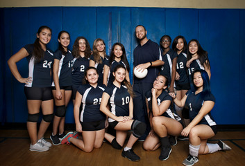 Portrait of teenage girl with volleyball coach 