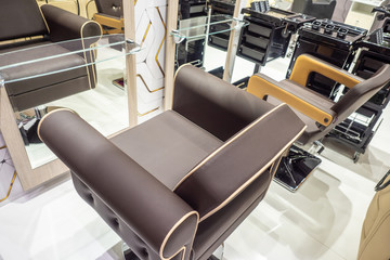 Barber chair. Furniture for the hairdressing salon. Hairdresser equipment. Bright interior of a beauty salon.