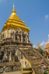 Fototapeta premium Old elephant chedi with golden top pagoda at Wat Chiang Man or Wat Chiang Mun, the oldest temple in Chiang Mai, Thailand, built in 1296 by King Mengrai in Lanna-style with elephant-shaped buttresses.