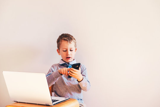 Child working with his computer in his business, concentrated typing to succeed, funny image.