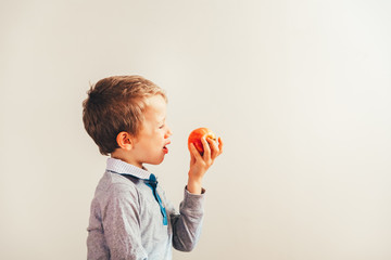 Angry and sad child forced to eat an apple.
