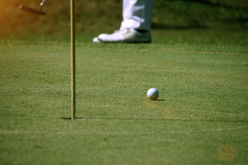 Blurred golfers are putting golf in the evening golf course in Thailand