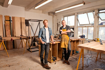 Portrait of mid adult men  in carpentry workshop 