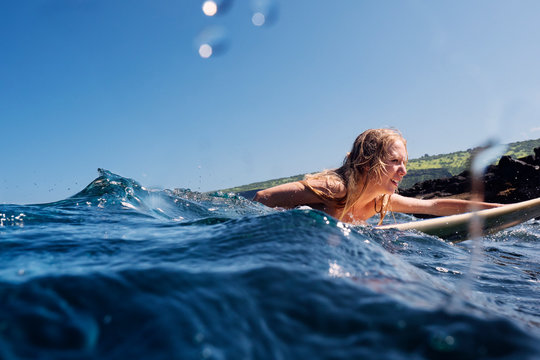 Young woman surfing at sunny day 