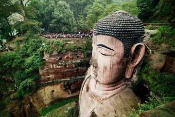 Leshan Giant Buddha The Leshan Giant Buddha  was built during the Tang Dynasty (618?907AD). It is carved out of a cliff face that lies at the confluence of the Minjiang, Dadu and Qingyi rivers in the southern part of Sichuan province in China, near the city of Leshan. The stone sculpture faces Mount Emei, with the rivers flowing below his feet. It is the largest Buddha in the world and it is by far the tallest pre-modern statue in the world.