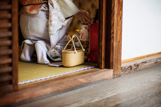 Close-up wooden architecture,  low section of female kneeling,  intertwined basket, 