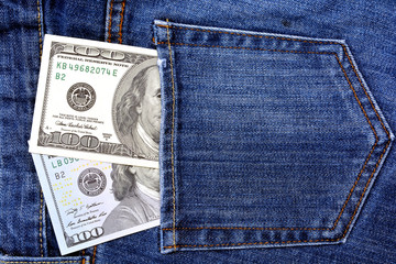 Paper banknotes of 100 us dollars in the back pocket of blue jeans. Denim backgrounds.