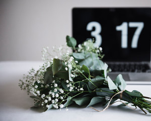 Bunch of flowers and clock on table 