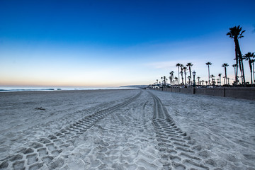 Beach at dawn with tracks in the sand 