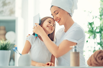 Mother and daughter combing hair