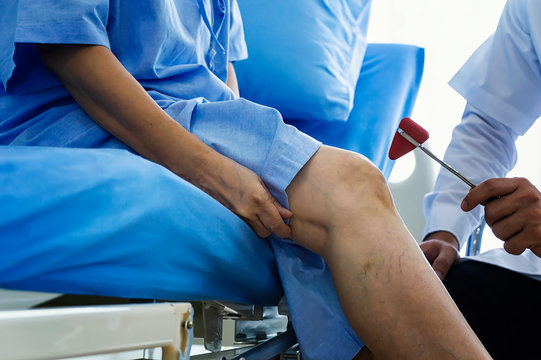 Close-up of female physiotherapist massaging the leg of patient in a physio room.