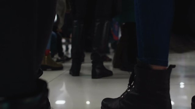 Legs of people crowd waiting for checking in at airport or hotel, queue to bank