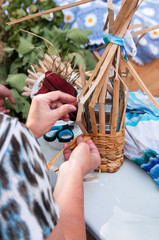 Russia, Khabarovsk, August 18, 2018: Folk handicrafts, women's hands weave a basket of straw at the harvest festival