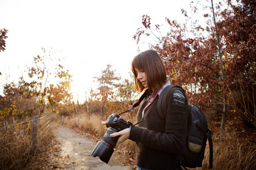 Amateur photographer adjusting her camera 