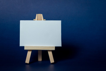 wooden easel with blank canvas isolated on blue