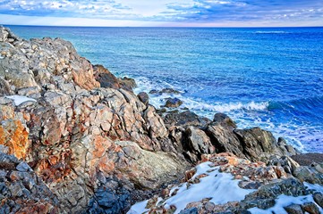 Snowy and rocky overlook of the ocean and coast during winter