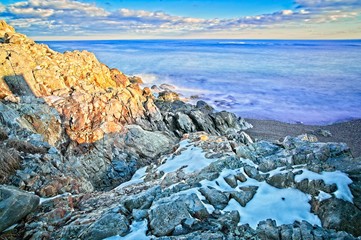 Snowy and rocky overlook of the ocean and coast during winter