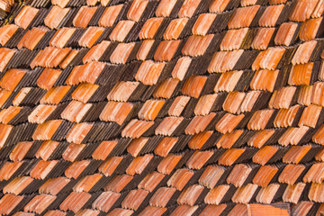 Abstract piles and packs of a new clay ceramic tiles to cover the roof of a Buddhist temple. Stack of new orange roof tiles in the building construction site for background.