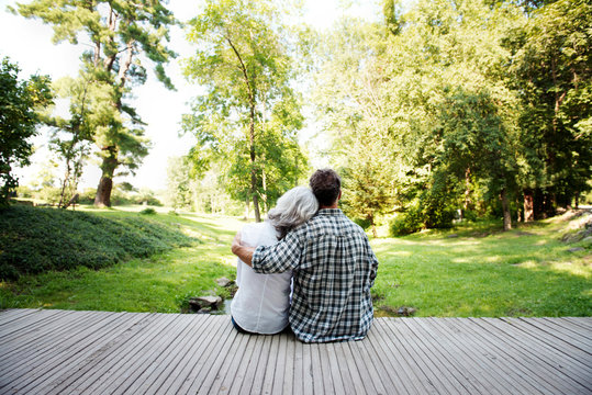 Mature couple embracing on patio overlooking backyard 