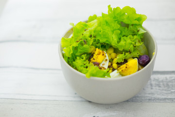 Fresh lettuce salad with yam and boiled egg with salad dressing.