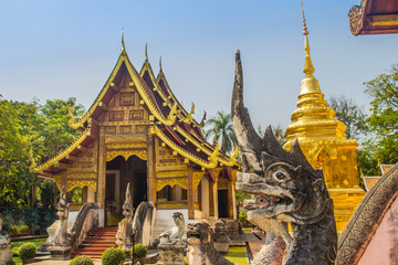 Fototapeta premium Lanna style Buddhist church at Wat Phra Singh(Temple of the Lion Buddha) with blue sky background. Wat Phra Singh is an important Buddhist monastery and temple on the west side of Chiang Mai, Thailand