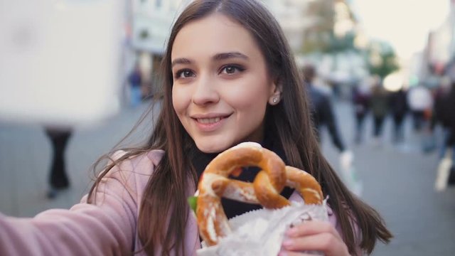 Beautiful girl making video about traditional German pretzel, culinary blog