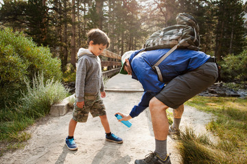 Man spraying insect repellent on son 