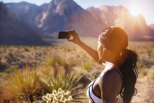 Young woman photographing in desert, 