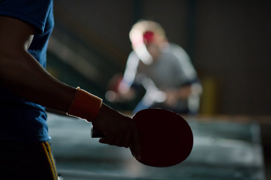 Two men playing table tennis at night 