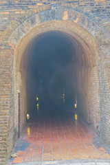 Ancient tunnels at Wat Umong Suan Puthatham, a 700-year-old Buddhist temple in Chiang Mai, Thailand. The tunnels were supposedly built by the King Mangrai in 1297 and painted with bush scenes.