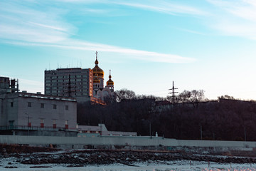Fototapeta premium View of the city of Khabarovsk from the Amur river at dawn. Frozen river. The industrial look.