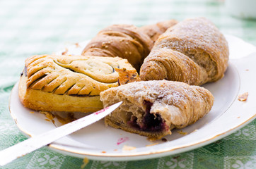 croissant with jam and cup of coffee on wooden table