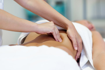 Woman having abdomen massage by professional osteopathy therapist - obrazy, fototapety, plakaty