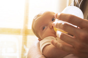 Man feeding his baby son (0-1 months) 